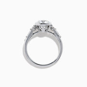The Star Lab Grown Diamond Moderne Ring in 18K White Gold showcases a large round center diamond with two smaller diamonds on each side, set on a sleek, polished band against a white background.
