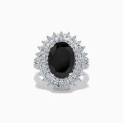The 14K White Gold Onyx and Diamond Double Halo Ring features a large oval onyx surrounded by two rows of sparkling white diamonds, set on a white gold band and displayed against a white background.