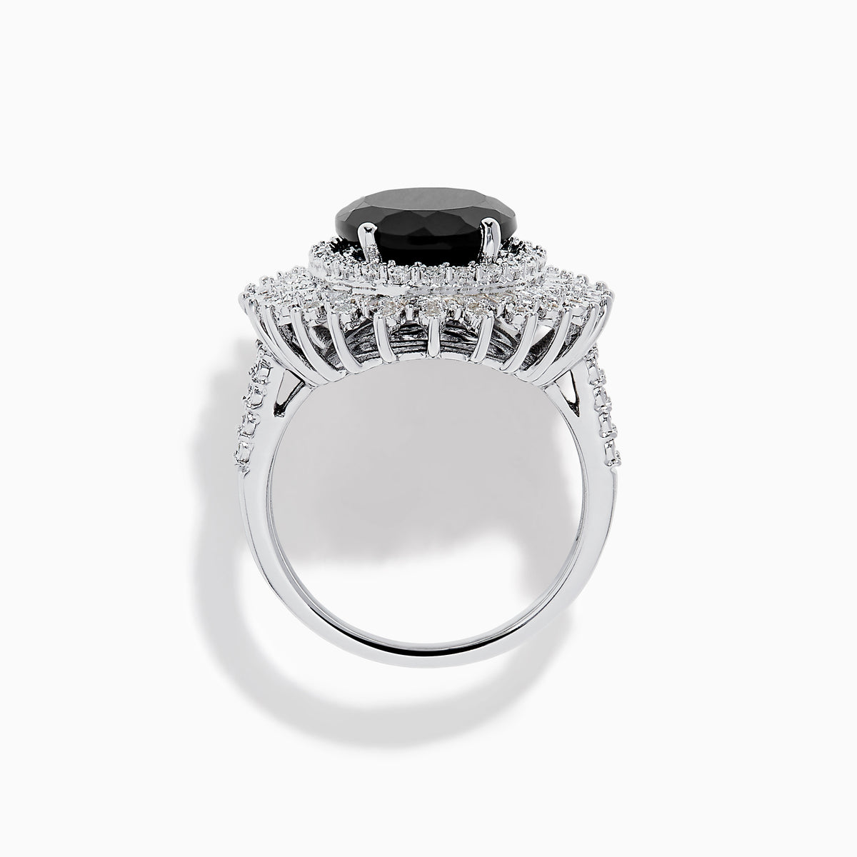 The 14K White Gold Onyx and Diamond Double Halo Ring features a large oval onyx surrounded by two rows of sparkling white diamonds, set on a white gold band and displayed against a white background.