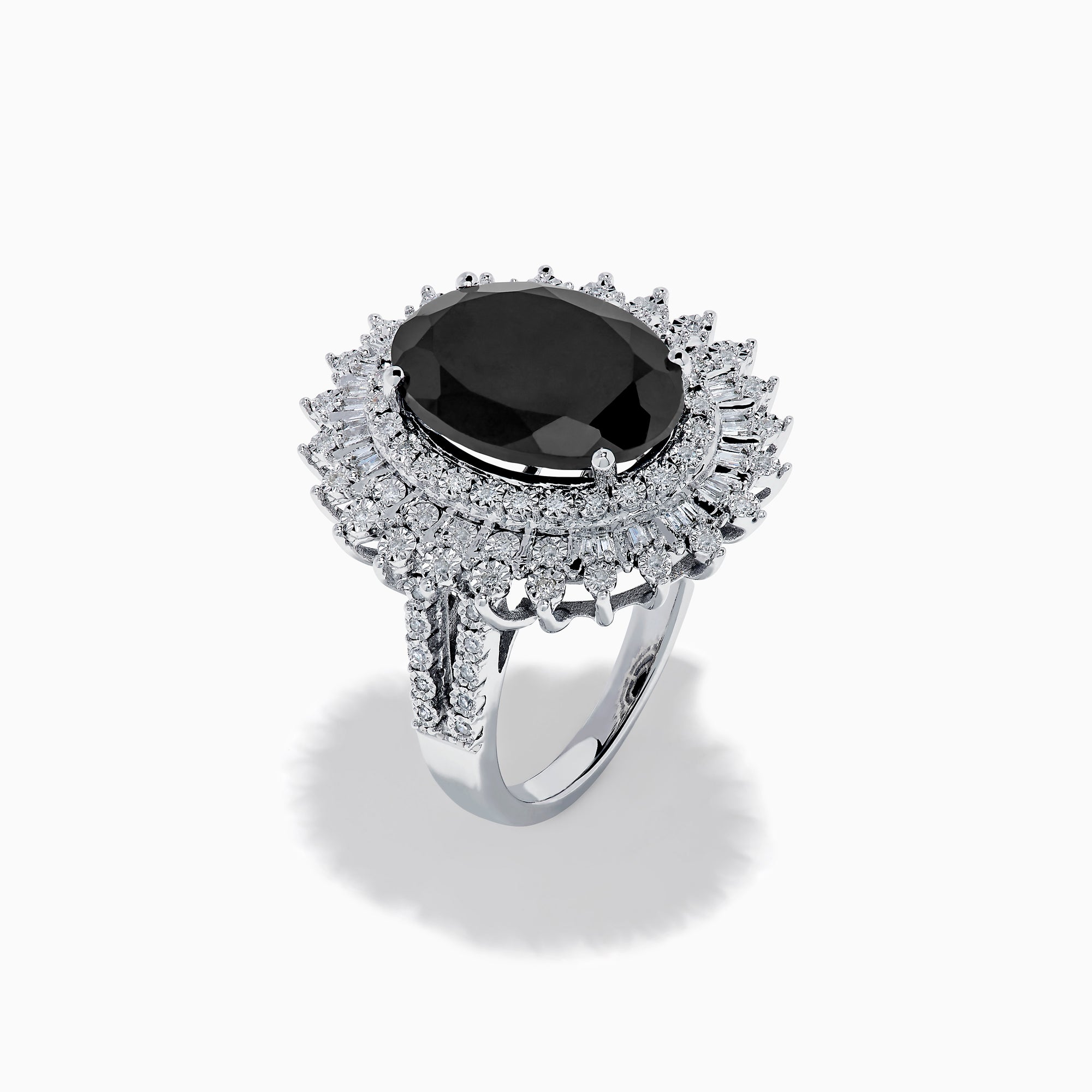 The 14K White Gold Onyx and Diamond Double Halo Ring features a large oval onyx surrounded by two rows of sparkling white diamonds, set on a white gold band and displayed against a white background.