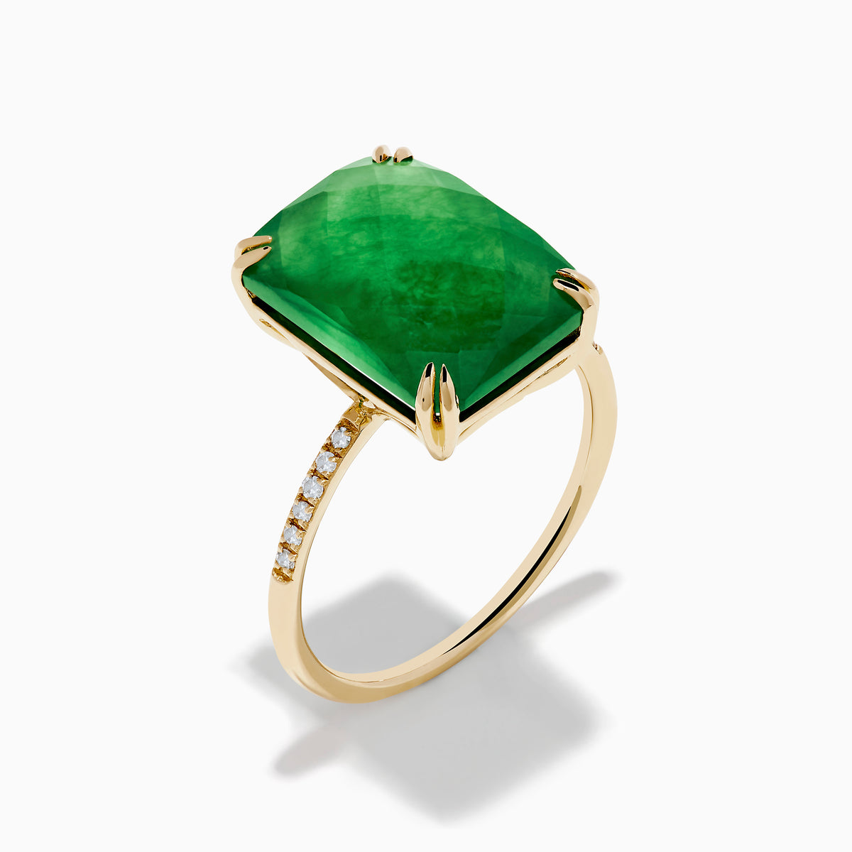 The 14K Yellow Gold Green Jade and Diamond Ring showcases a large rectangular green jade gemstone set with four prongs, complemented by small diamond accents on each side of the band.
