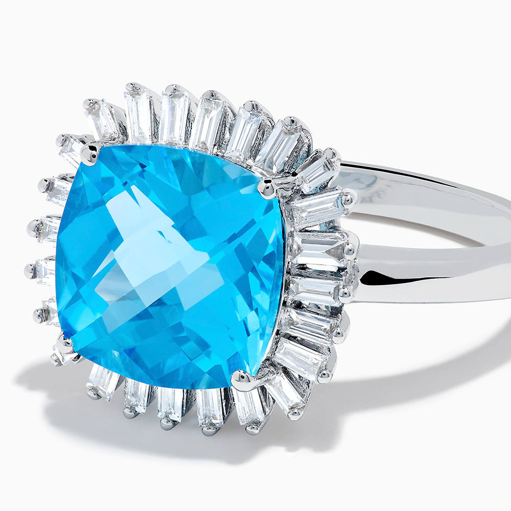 The Ocean Bleu 14K White Gold Blue Topaz and Diamond Halo Ring features a large cushion-cut blue topaz center stone, surrounded by a sparkling halo of baguette-shaped diamonds, all set in elegant white gold.