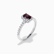 The Effy Hematian 14K White Gold Ring features a cushion-cut alexandrite center stone, surrounded by a diamond halo and additional diamonds set along the band.