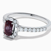 The Effy Hematian 14K White Gold Ring features a cushion-cut alexandrite center stone, surrounded by a diamond halo and additional diamonds set along the band.