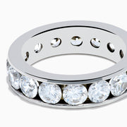 The 14K White Gold Channel Set Diamond Eternity Band, 4.00 TCW, features brilliant round diamonds all around and is elegantly showcased on a plain white background.