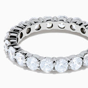 The 14K White Gold Prong Set Diamond Eternity Band, 3.00 TCW, features round diamonds encircling the band and is shown on a plain white background.