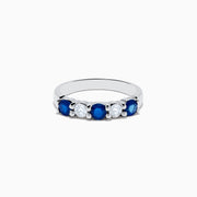 The 14K White Gold Blue Sapphire and Diamond Ring, 1.14 TCW, showcases three round blue sapphires and two round diamonds set alternately across the band against a plain white background.
