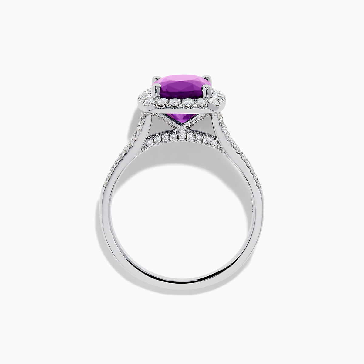 The 18K White Gold Purple Sapphire and Diamond Halo Ring showcases a cushion-cut purple sapphire center, encircled by a diamond halo and diamonds along the band.