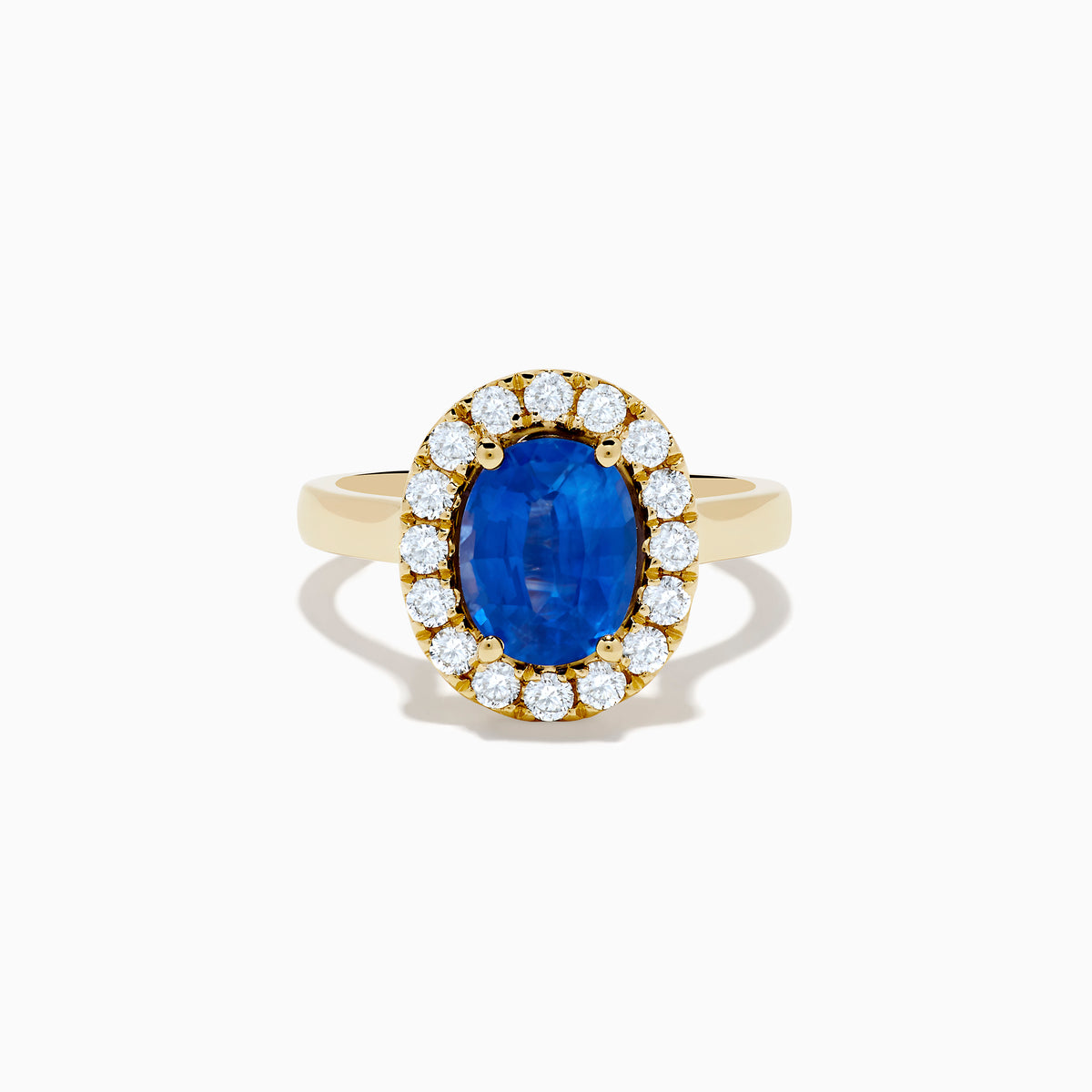 The Royale Bleu 18K Yellow Gold Blue Sapphire and Diamond Halo Ring showcases a striking oval blue sapphire centerpiece surrounded by a sparkling diamond halo.