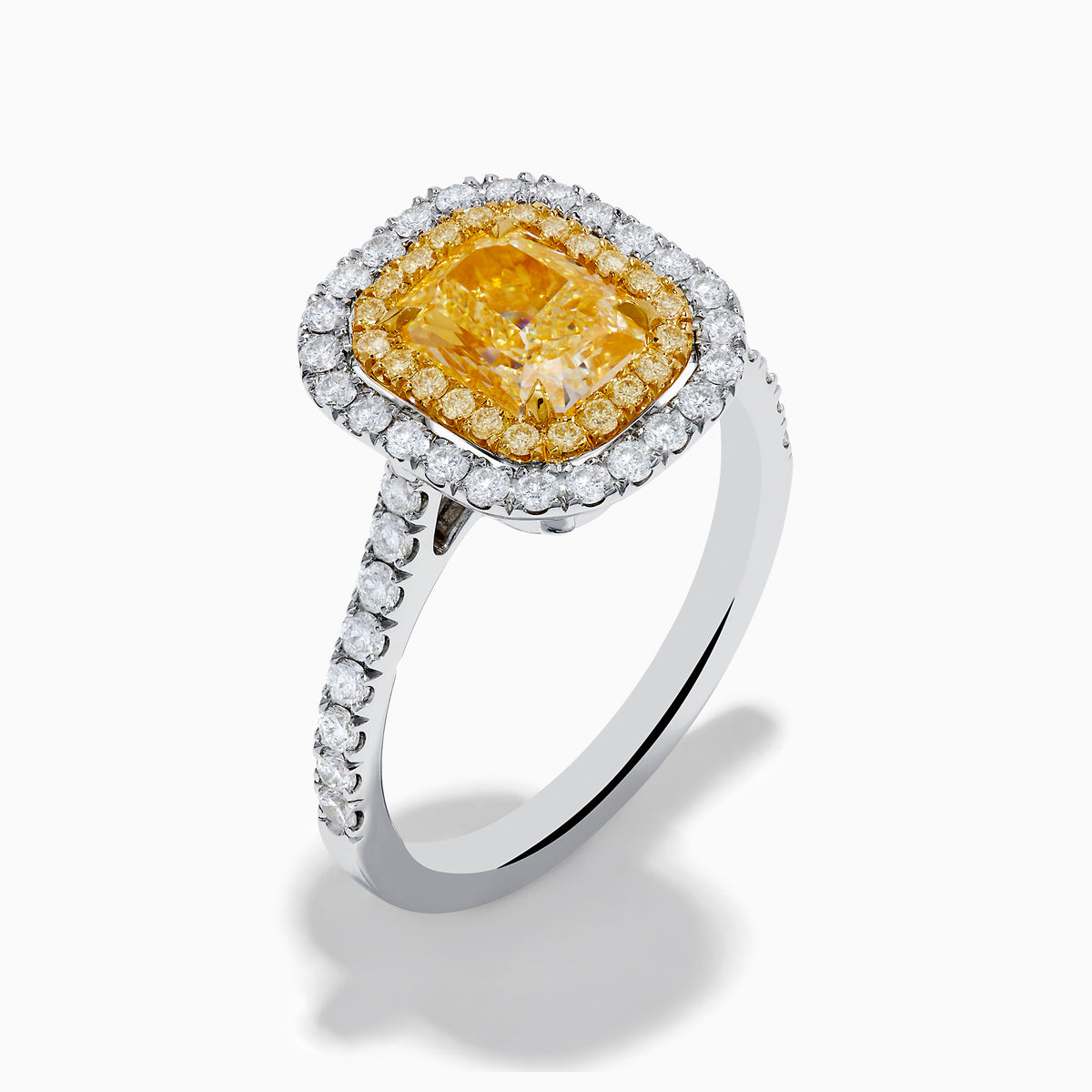 The 18K Gold Yellow and White Double Halo GIA Certified Diamond Ring showcases a large rectangular yellow diamond center, framed by double halos of round white diamonds and a diamond-adorned band.
