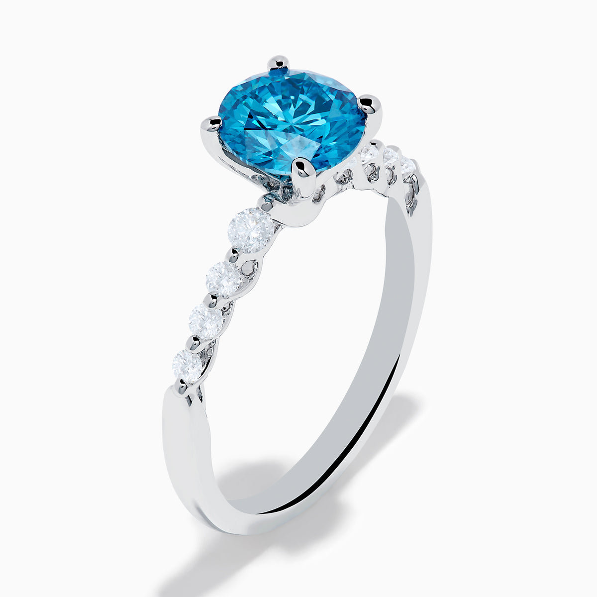 The Lab Grown Blue and White Diamond Ring set in 14K White Gold features a large round blue and white diamond at the center, accented by smaller clear stones, displayed against a white background.