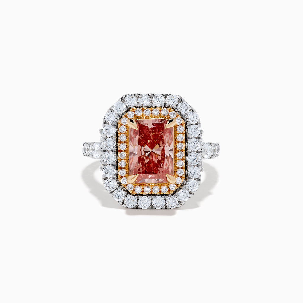 The Lab Grown Pink Diamond Double Halo Cocktail Ring in 14K White Gold features a rectangular pink diamond center, with white and yellow diamonds on a silver band, displayed against a white background.