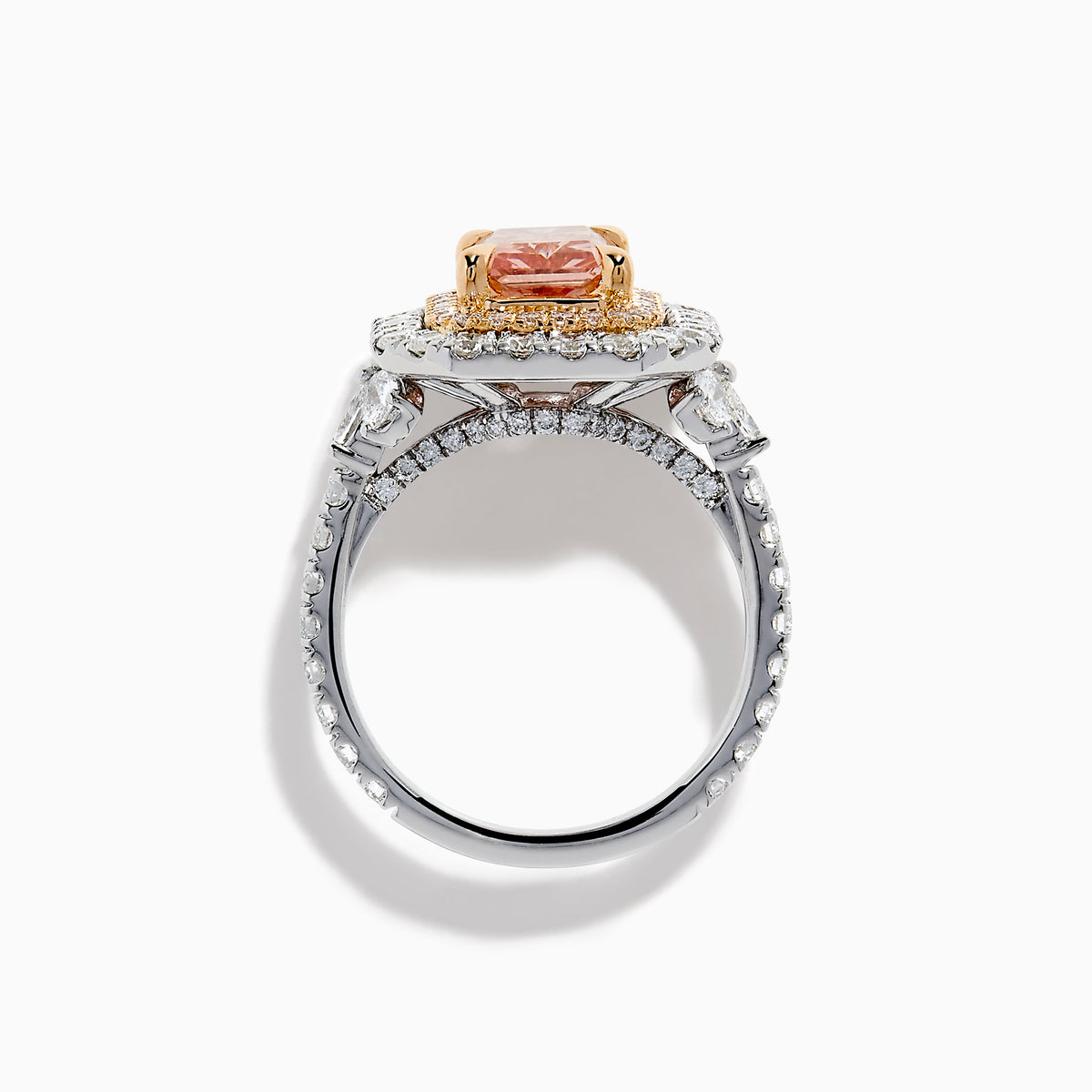 The Lab Grown Pink Diamond Double Halo Cocktail Ring in 14K White Gold features a rectangular pink diamond center, with white and yellow diamonds on a silver band, displayed against a white background.