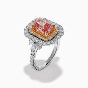 The Lab Grown Pink Diamond Double Halo Cocktail Ring in 14K White Gold features a rectangular pink diamond center, with white and yellow diamonds on a silver band, displayed against a white background.