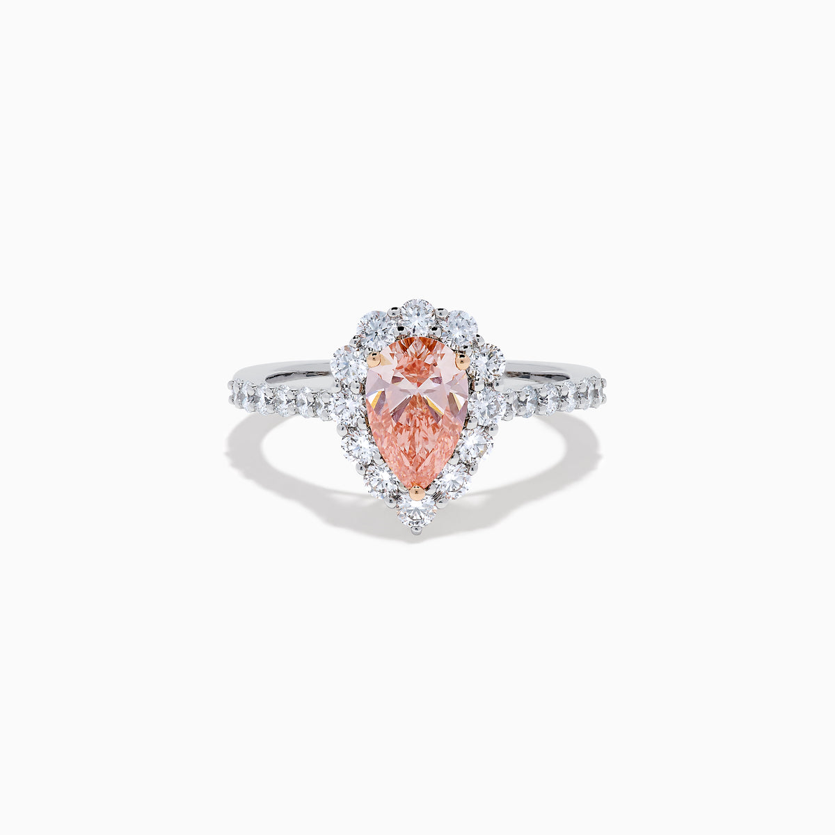 The Lab Grown Pink and White Diamond Halo Ring in 14K Two Tone Gold features a pear-shaped pink center, a halo of white diamonds, and a diamond-studded band, shown on a white background.