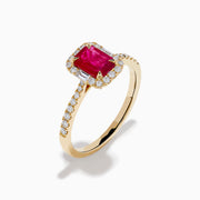 The Ruby Royale 14K Yellow Gold Ruby and Diamond Halo Ring features a rectangular ruby center, surrounded by a halo of round and baguette diamonds, with extra diamond accents on the band for added brilliance.