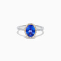 The Nahla 14K Two Tone Gold Tanzanite and Diamond Halo Ring features an oval blue tanzanite center, encircled by a diamond halo and diamond-accented band, all set in elegant two-tone 14K gold.