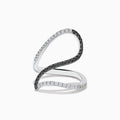 The 14K White Gold Black and White Diamond Fashion Ring features an open, wavy design with intertwined bands of sparkling white and black diamonds, creating a modern and elegant look.