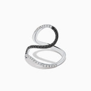 The 14K White Gold Black and White Diamond Fashion Ring features an open, wavy design with intertwined bands of sparkling white and black diamonds, creating a modern and elegant look.