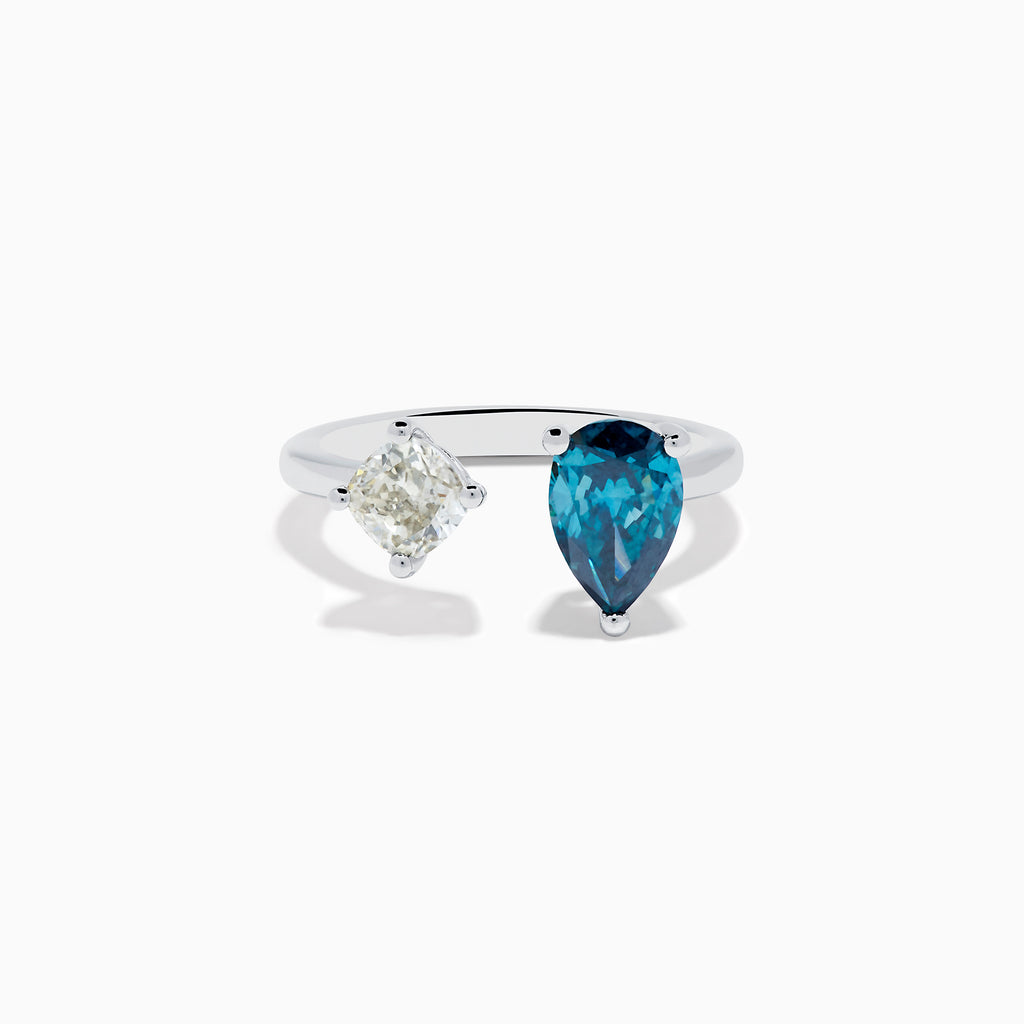 The 14K White Gold Blue and White Diamond Toi Et Moi Ring features a pear-shaped blue diamond and a square white diamond set side by side on an open band, displayed against a white background.