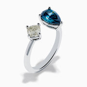 The 14K White Gold Blue and White Diamond Toi Et Moi Ring features a pear-shaped blue diamond and a square white diamond set side by side on an open band, displayed against a white background.