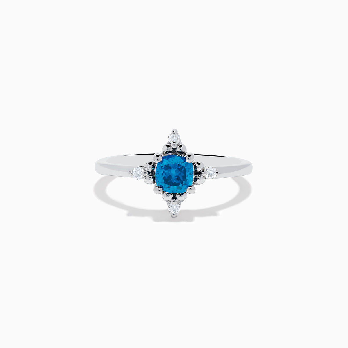 The 14K White Gold Blue and White Diamond Ring features a round blue diamond center with small white stones in a compass pattern, displayed on a white background.