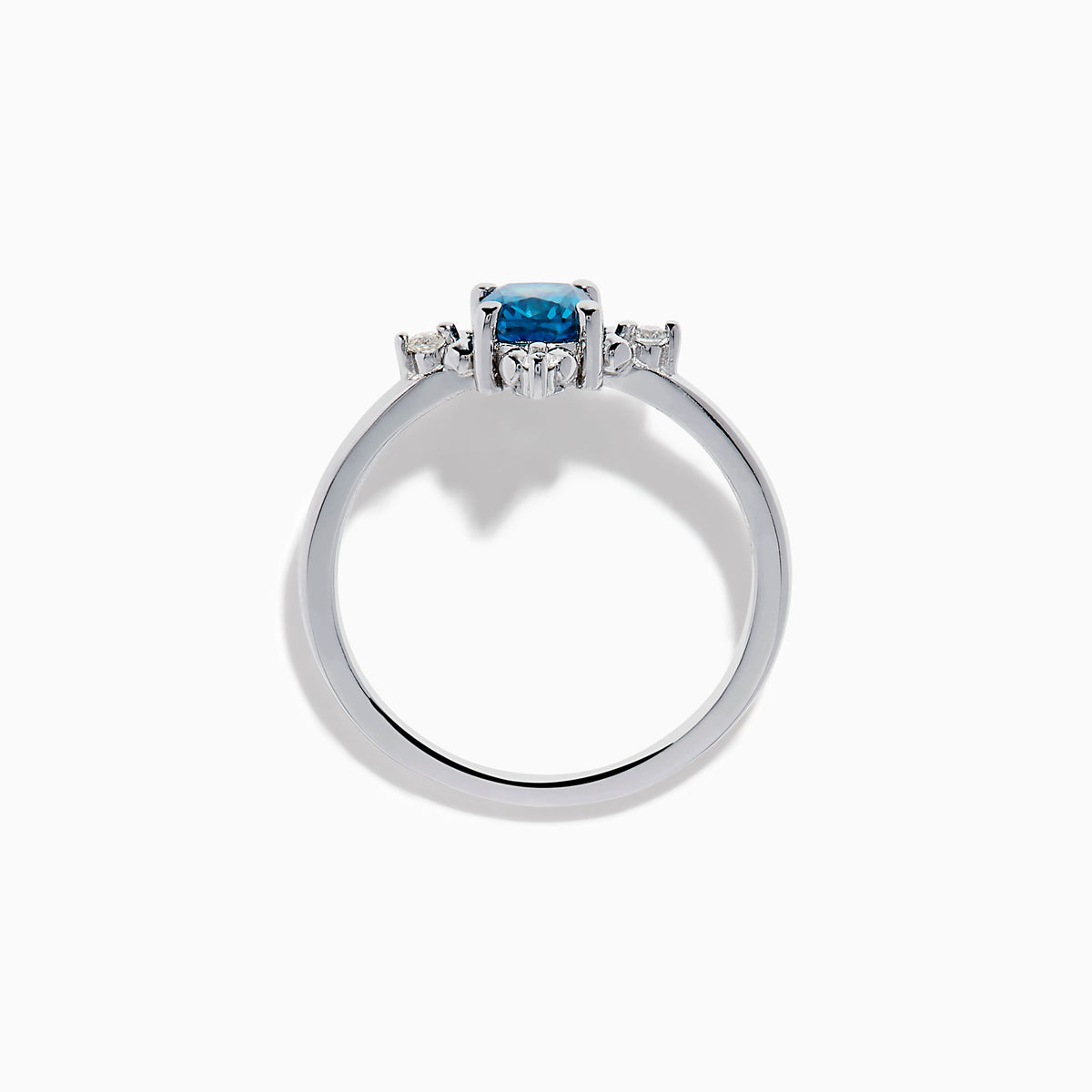 The 14K White Gold Blue and White Diamond Ring features a round blue diamond center with small white stones in a compass pattern, displayed on a white background.
