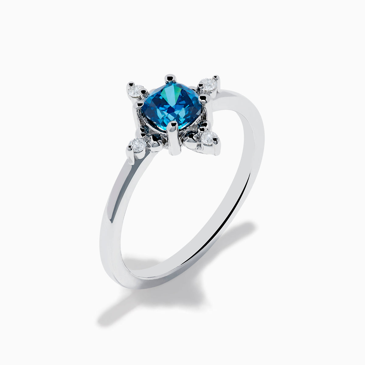 The 14K White Gold Blue and White Diamond Ring features a round blue diamond center with small white stones in a compass pattern, displayed on a white background.