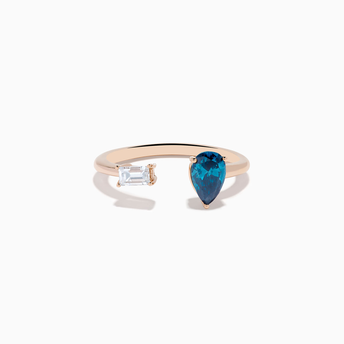 The 14K Rose Gold Blue and White Diamond Toi Et Moi Ring features an open design with a clear rectangular diamond and a blue teardrop diamond, elegantly displayed on a white background.
