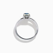 The 14K White Gold Blue and White Diamond Split Shank Ring features a clear oval and blue cushion-cut gemstone set side by side on a minimalist band, showcasing striking contrast between the blue and white diamond accents.