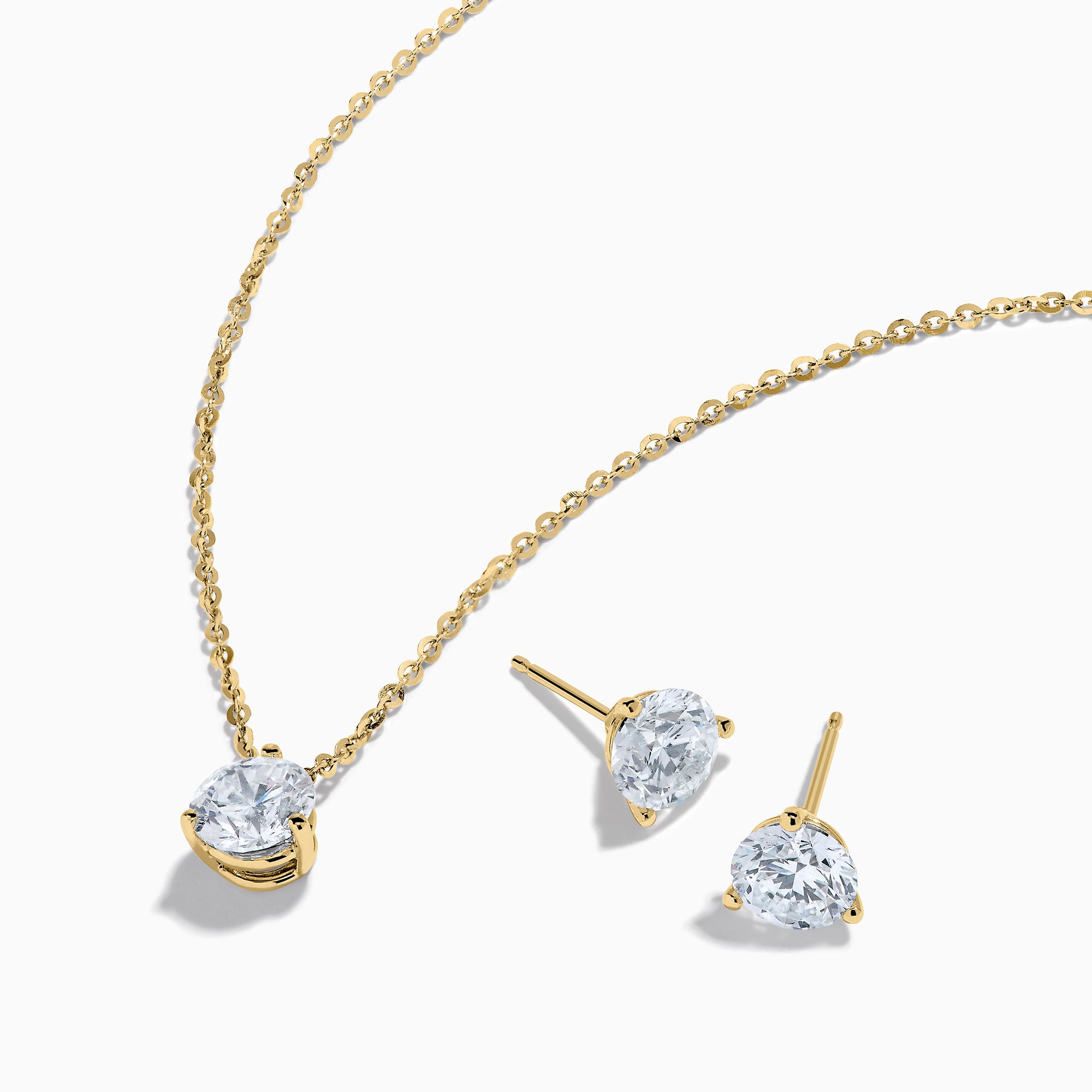 The Lab Grown Diamond Earring and Necklace Set in 14K Yellow Gold features a round diamond pendant and matching gold stud earrings, each showcasing a single round lab grown diamond, displayed on a white background.