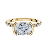 An 18K yellow gold engagement ring featuring a cathedral dome design, east/west bezel and half bezel setting, and a 2.5mm band accented with a single row of pave diamonds.