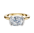 An 18K two-tone bezel half bezel East/West cathedral dome engagement ring (2.0mm) with a large cushion-cut diamond, set in a modern setting with white metal prongs, displayed on a plain white background.