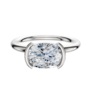 A 14K white gold bezel half bezel east/west classic dome 2.0mm engagement ring is shown with a large, round diamond set in a modern cushion-shaped setting against a plain white background.