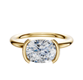 An 18K yellow gold Dome 2.0mm engagement ring featuring a classic half bezel east/west setting, offering simple elegance and highlighting the brilliance of your chosen center stone.