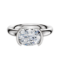 A Platinum Bezel Half Bezel East/West Classic Dome 3.0mm Engagement Ring with a large cushion-cut clear gemstone set in a modern, minimalist band, secured by two prongs on each side. The background is plain white.