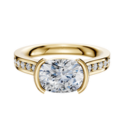 The 18K Yellow Gold Bezel Half Bezel East/West Cathedral Flat 1-Row-Pave 2.5mm Engagement Ring features a large center diamond and small diamonds along the band, showcased against a plain white background.