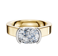 The 14K Two Tone Bezel Half Bezel East/West Cathedral Flat 4.0mm Engagement Ring features a wide band and modern setting, showcasing a striking center stone in a stylish east-west orientation with elegant bezel details.