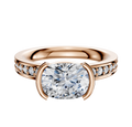 A 14K rose gold engagement ring featuring a classic flat band with 1-row pave, set in an east/west bezel style.