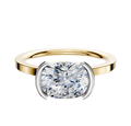 An 18K two-tone bezel half bezel East/West classic flat 1.5mm engagement ring photographed against a plain white background.