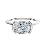 An 18K white gold bezel half bezel East/West cathedral knife edge 1.5mm engagement ring is displayed against a plain white background.