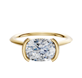 A 14K yellow gold engagement ring with a 1.5mm knife edge band in an east/west cathedral bezel and half bezel setting, displayed on a plain white background.