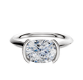 A 14K white gold bezel half-bezel East/West cathedral knife edge 2.0mm engagement ring is shown on a plain white background, featuring a modern and minimalist design.