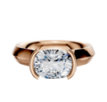 An 18K rose gold engagement ring with a wide knife edge band, featuring a 4.0mm cushion-cut clear gemstone in a modern, half bezel east/west cathedral setting.