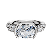 The 14K Two Tone Bezel Half Bezel East/West Classic Knife Edge 1-Row-Pave 2.5mm Engagement Ring features a unique east/west-set center, classic knife-edge design, and a band accented with a single row of sparkling pave diamonds.