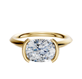 The 14K Yellow Gold Bezel Half Bezel East/West Classic Knife Edge 2.0mm Engagement Ring features a modern setting with a round cushion-cut diamond, presented against a plain white background.