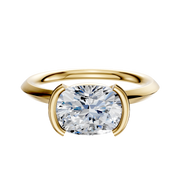 The 18K Yellow Gold Bezel Half Bezel East/West Classic Knife Edge 2.0mm Engagement Ring features a sparkling round diamond in a modern half bezel setting with a smooth, polished band highlighting the center stone.