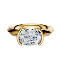 An 18K yellow gold Bezel Half Bezel East/West Classic Knife Edge 3.0mm engagement ring is showcased with a modern, minimalist setting, displayed on a plain white background.
