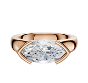 The 14K Rose Gold Bezel Half Bezel East/West Cathedral Dome 4.0mm Engagement Ring features a modern setting with polished metal framing a large, marquise-cut clear gemstone elegantly on two sides.
