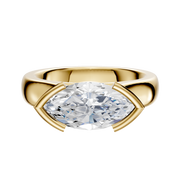 An 18K yellow gold East/West cathedral dome engagement ring with a 4.0mm marquise diamond in a minimalist half bezel, displayed on a plain white background.